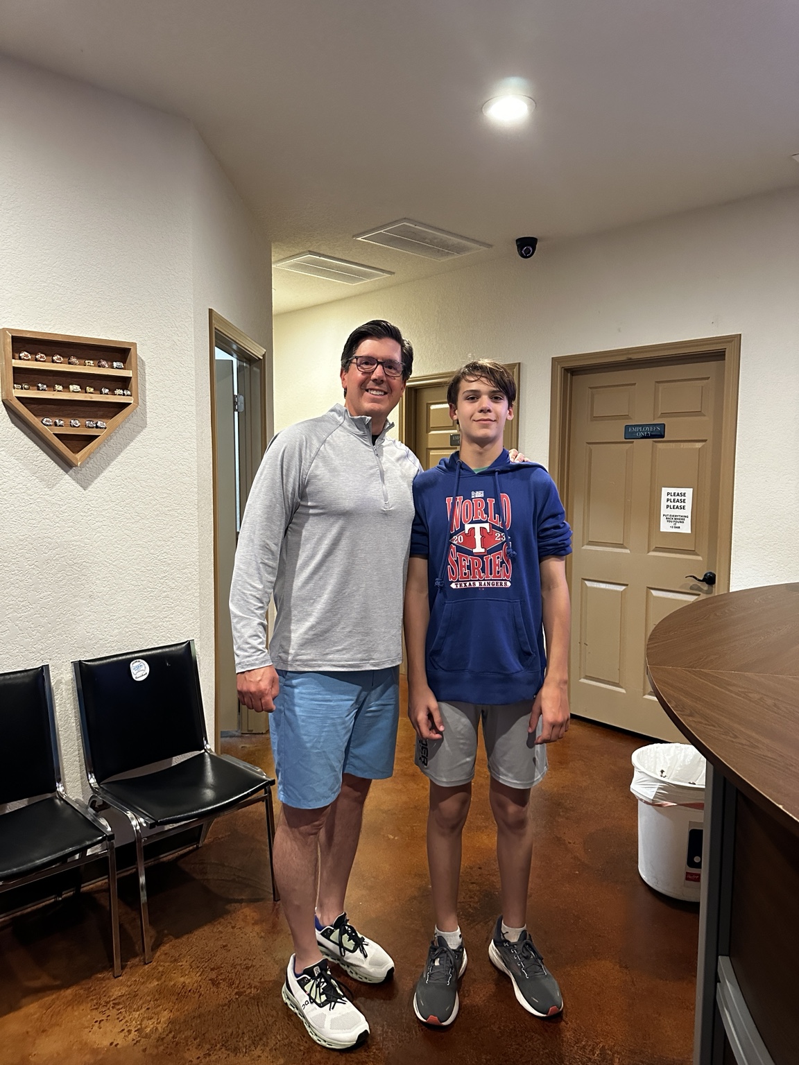 Patrick standing beside a young person indoors