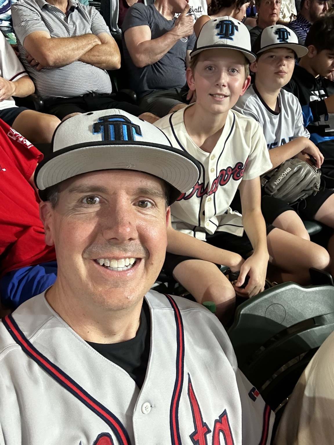 Patrick with young baseball players in the stadium stands