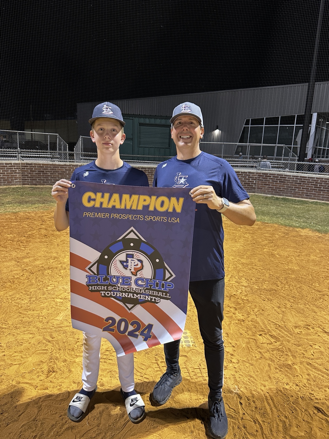 Patrick and a young baseball player holding a 2024 tournament champion banner
