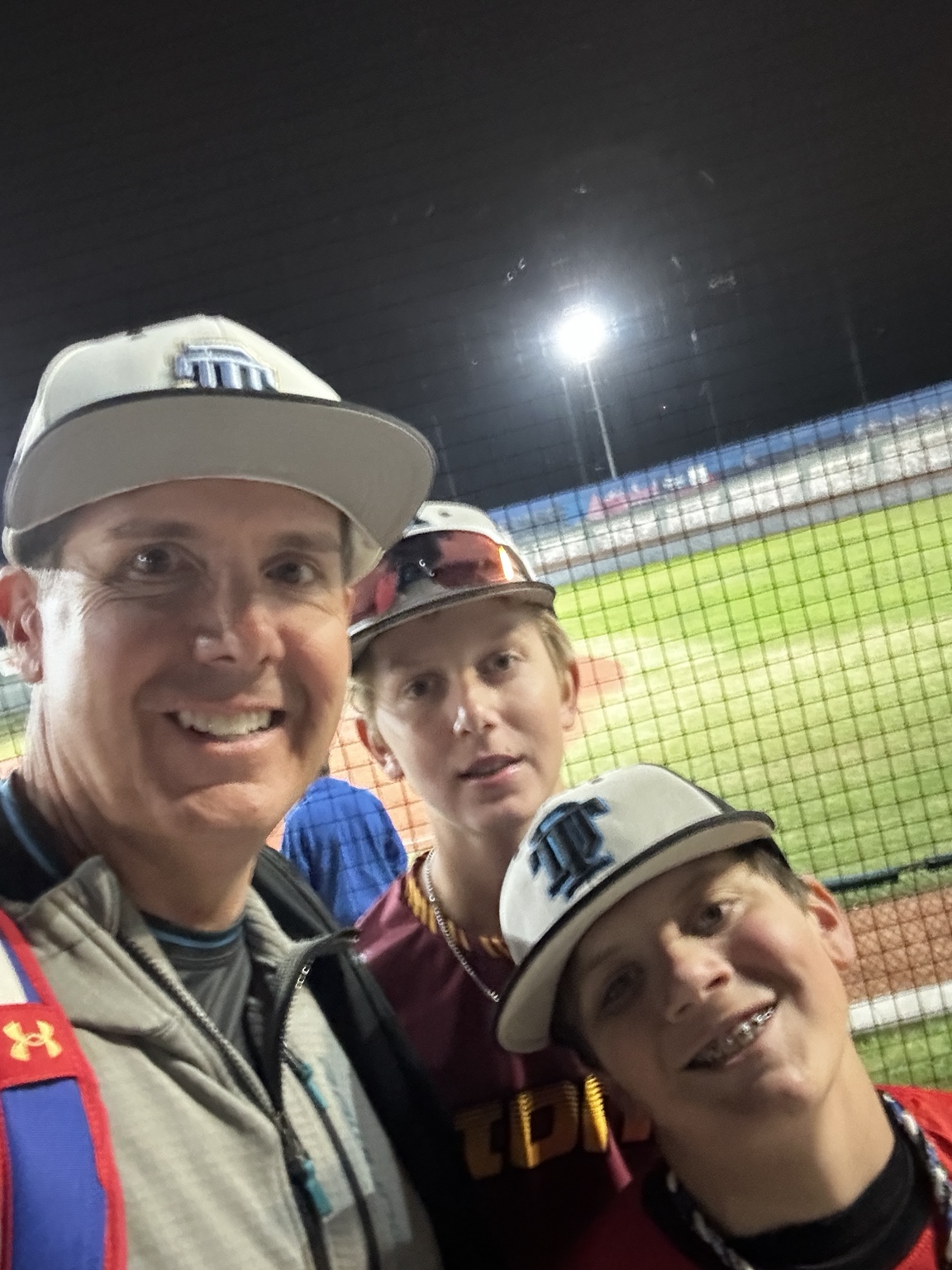 Patrick with two young baseball players at the ballpark